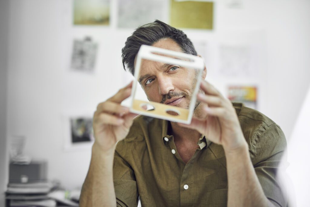 Portrait of man checking component in his office