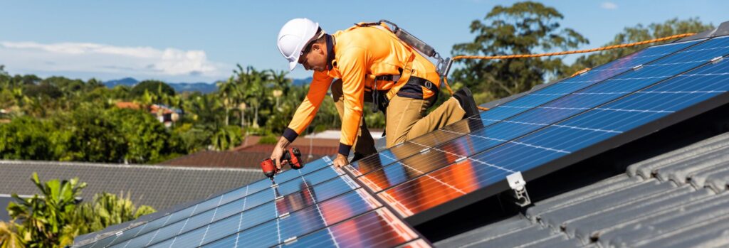 Solar panel technician with drill installing solar panels - clean energy innovation in Canada