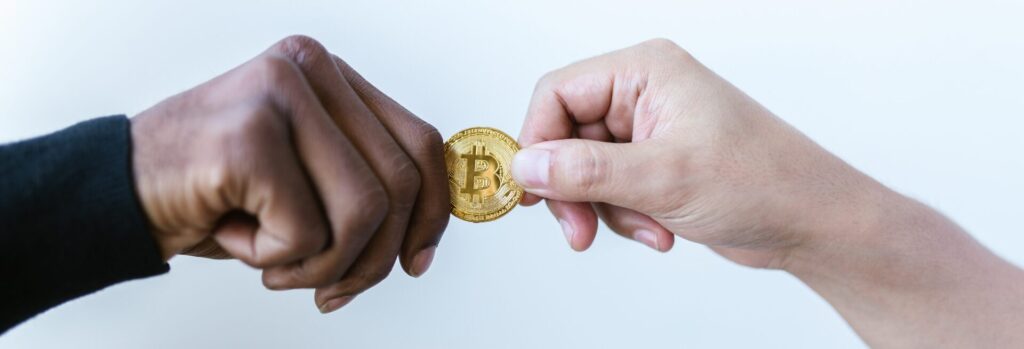 A person passing a bitcoin to another