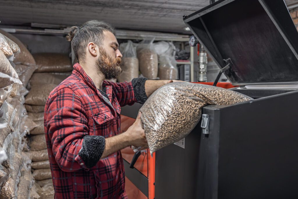Man fueling a thermal composting system with organic waste pellets for sustainable soil regeneration