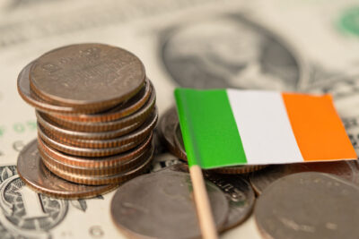 Stack of coins with Ireland flag on white background.