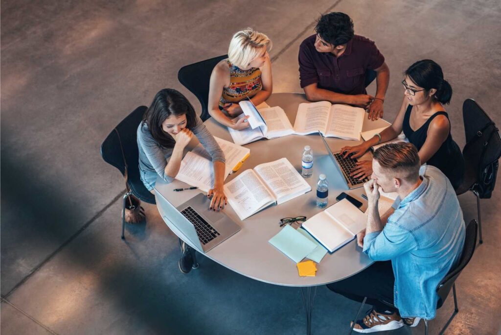 Il team tax di Leyton, composto da professionisti in abbigliamento formale, discute strategie e soluzioni fiscali intorno a un tavolo rotondo in un ambiente di ufficio moderno e collaborativo.