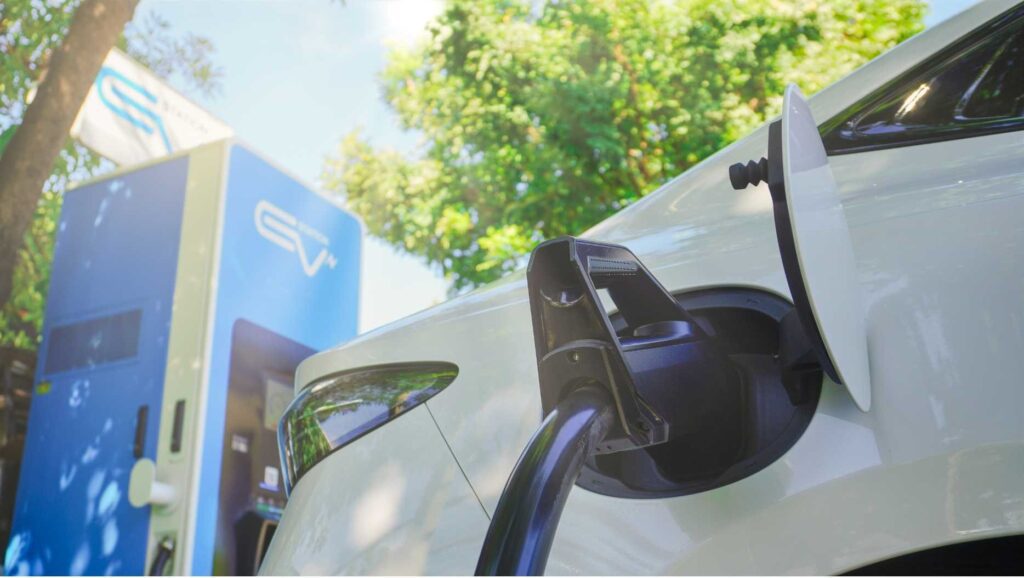 una-macchina-bianca-elettrica-attaccata-ad-una-collonnina-di-ricarica