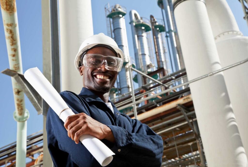 Un operaio sorride davanti all'industria per cui lavora. Imprese Energivore e Gasivore