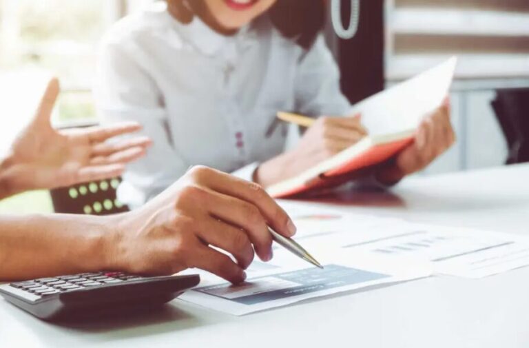 Due impiegati lavorano insieme, analzizando dei grafici.