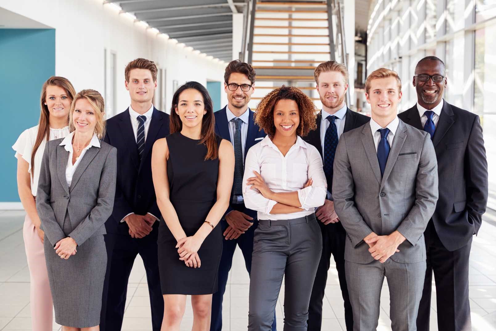 Un gruppo di professionisti in abiti formali si trova in un ufficio moderno.