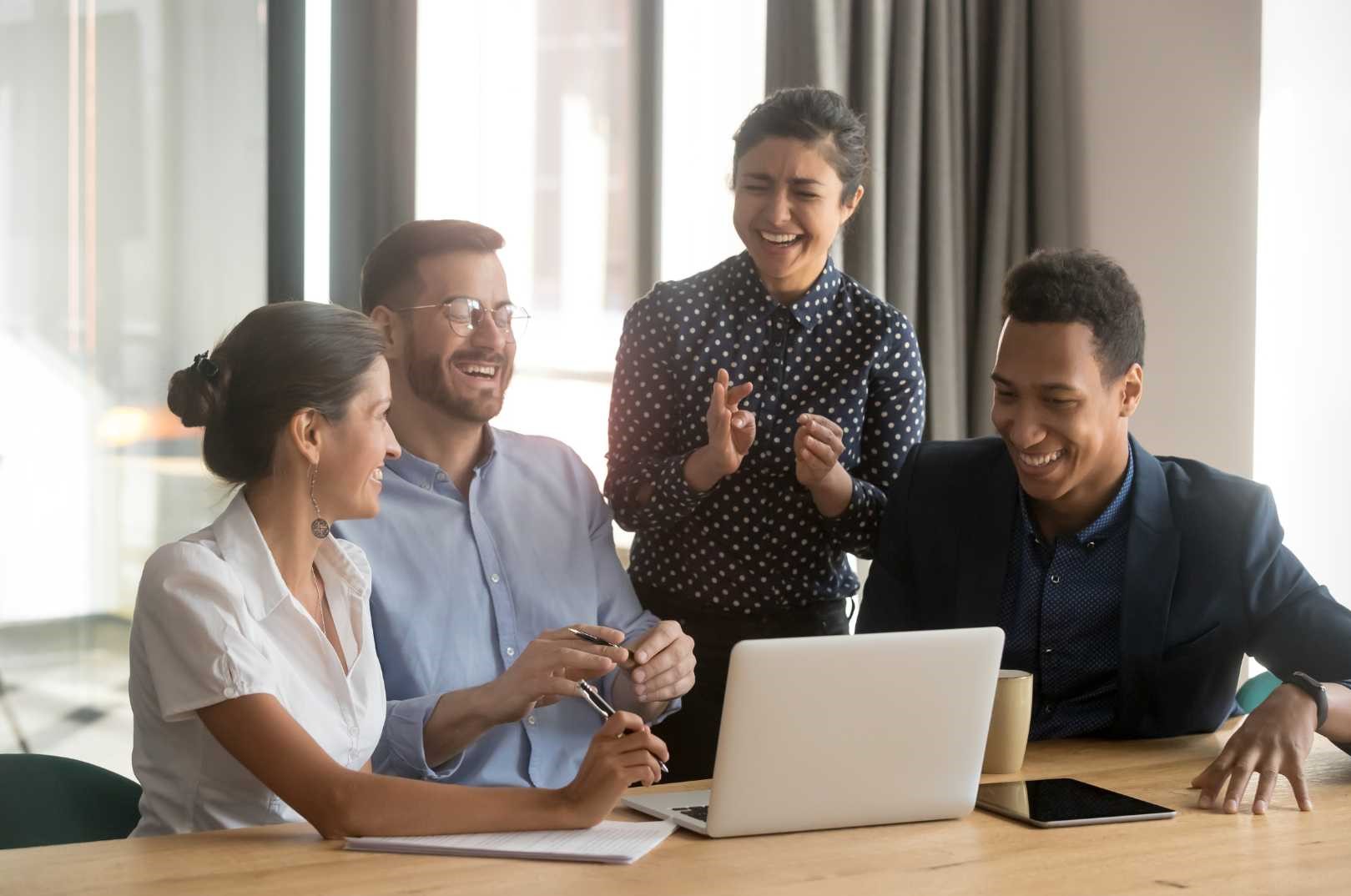 Un gruppo di persone sedute attorno a un tavolo, mentre utilizzano un laptop per discutere e collaborare. FAQ Transizione 5.0