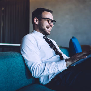 Consulente del dipartimento Transfer Pricing lavora al computer seduto sul divano.