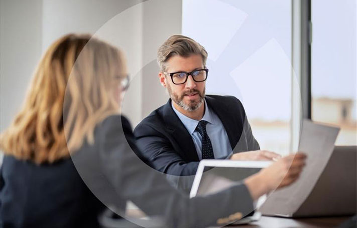 Un uomo e una donna parlano tra di loro in ufficio.