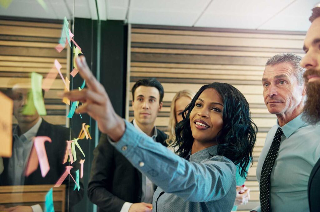 Dei colleghi di lavoro sorridno mentre guardano dei post-it.