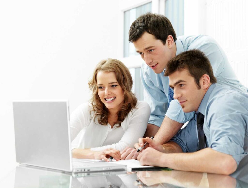 Team di persone lavorano insieme in ufficio davanti a un laptop. Crediti d’imposta Transizione 4.0