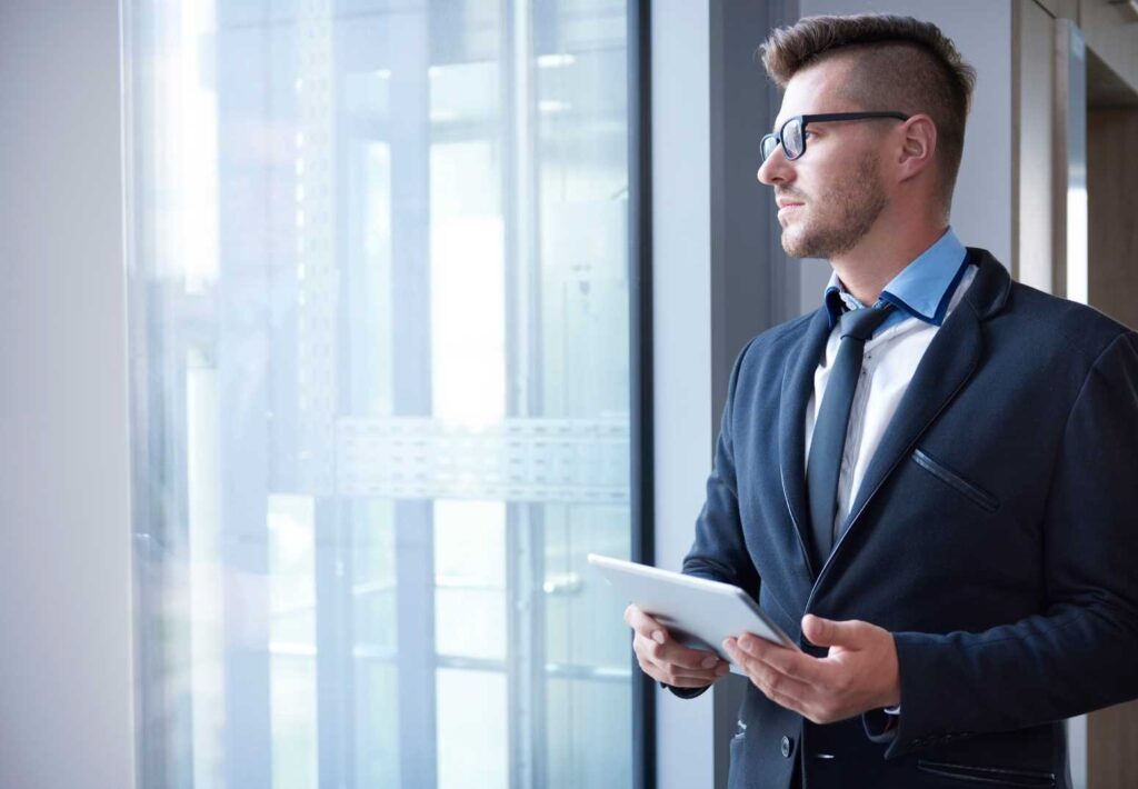 Un uomo in abiti eleganti mentre utilizza il suo tablet. Project Management.