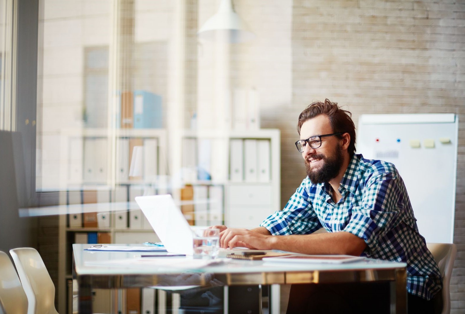 Un uomo lavora con il suo laptop in un ufficio luminoso. PNRR scadenze 2026.