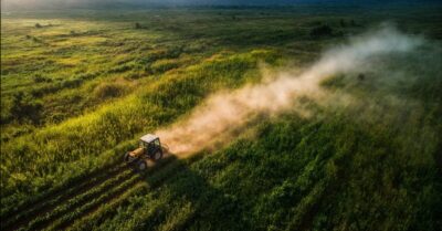 a tractor driving through the green field
