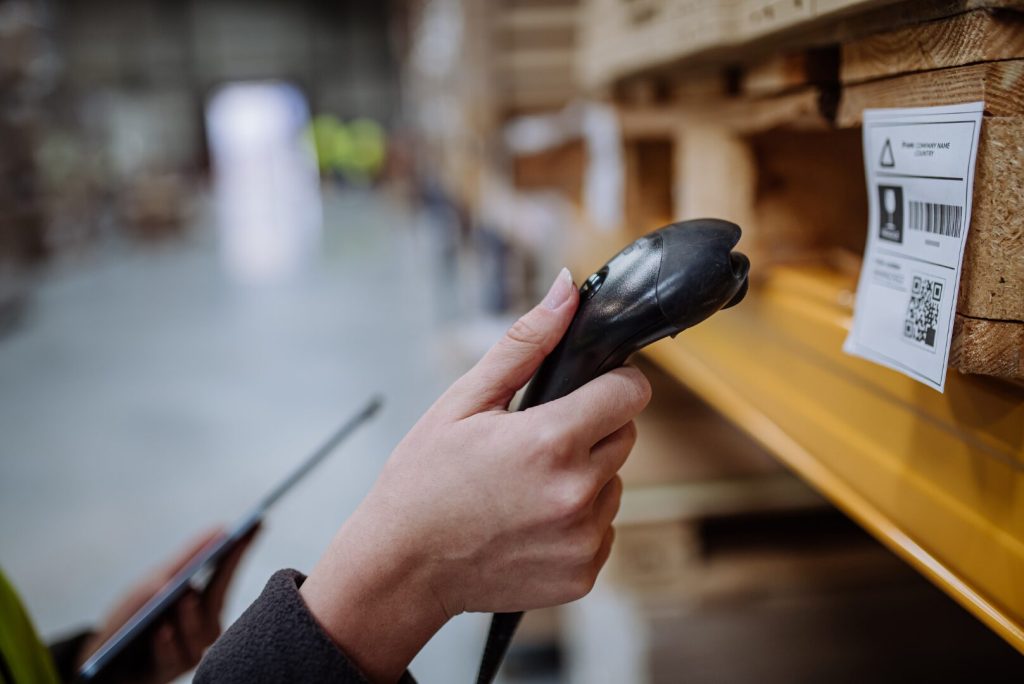 Una mano di un lavoratore che scansione un codice a barre