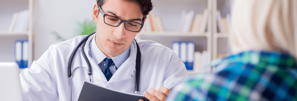 visite médicale doctor reading a paper in front of his patient