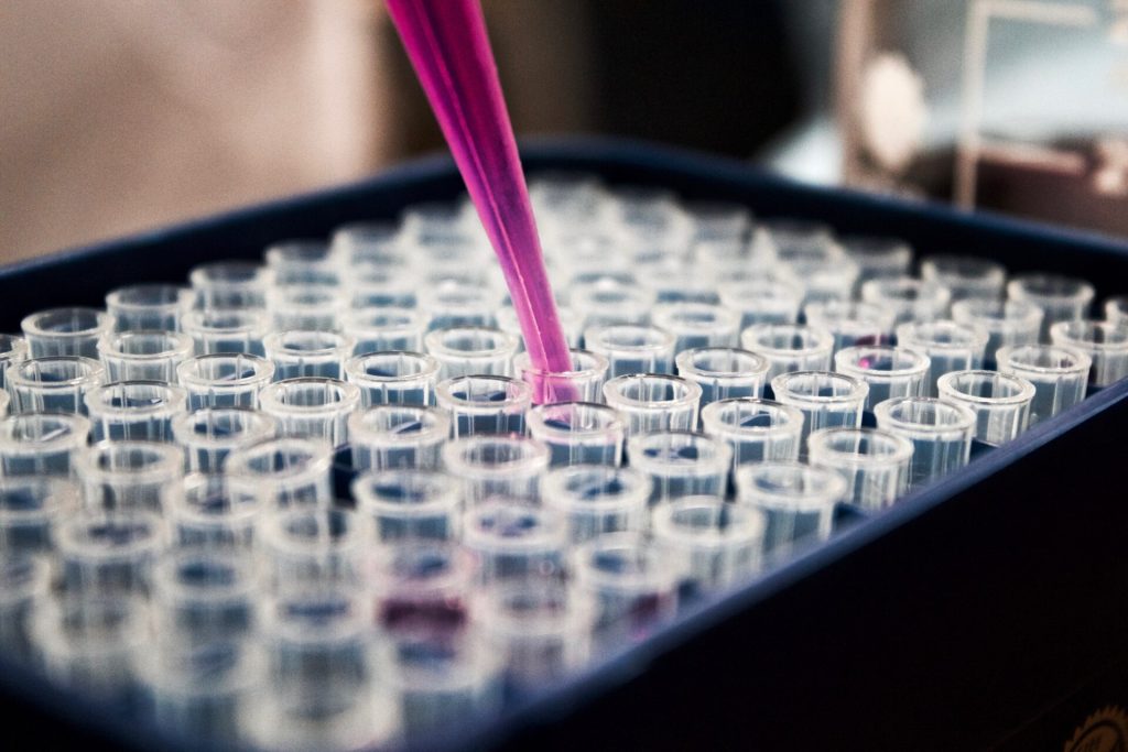 Photo of a laboratory setup with a pipette and a multiwell plate, representing the precision work of a Quebec-based accredited laboratory specialized in diagnostics and analysis for veterinary and agri-food sectors